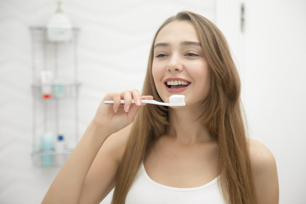 young smiling girl cleaning her teeth image